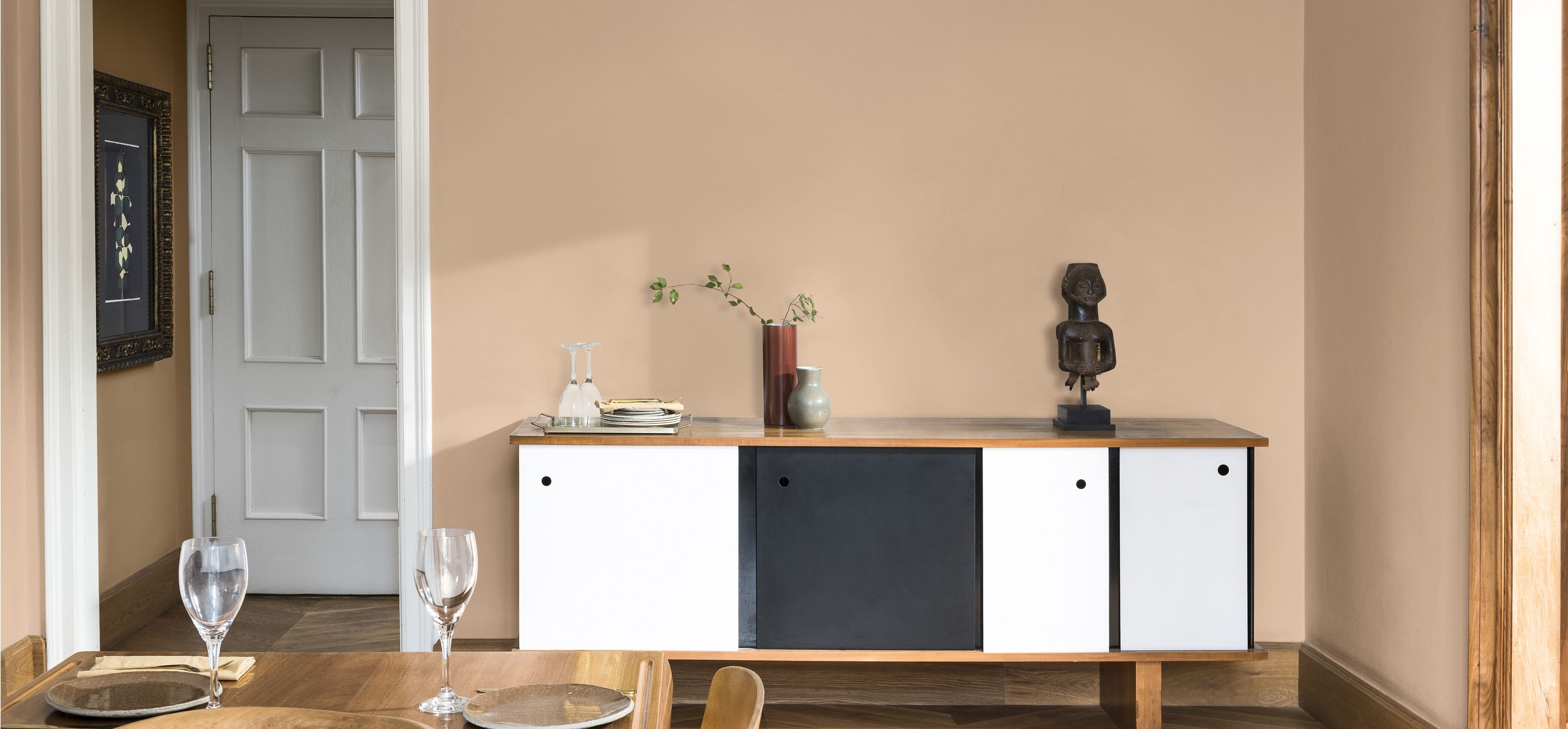 een eetkamer met vintage stoelen en muren in de kleuren Schemerroze en Joyful Ruby