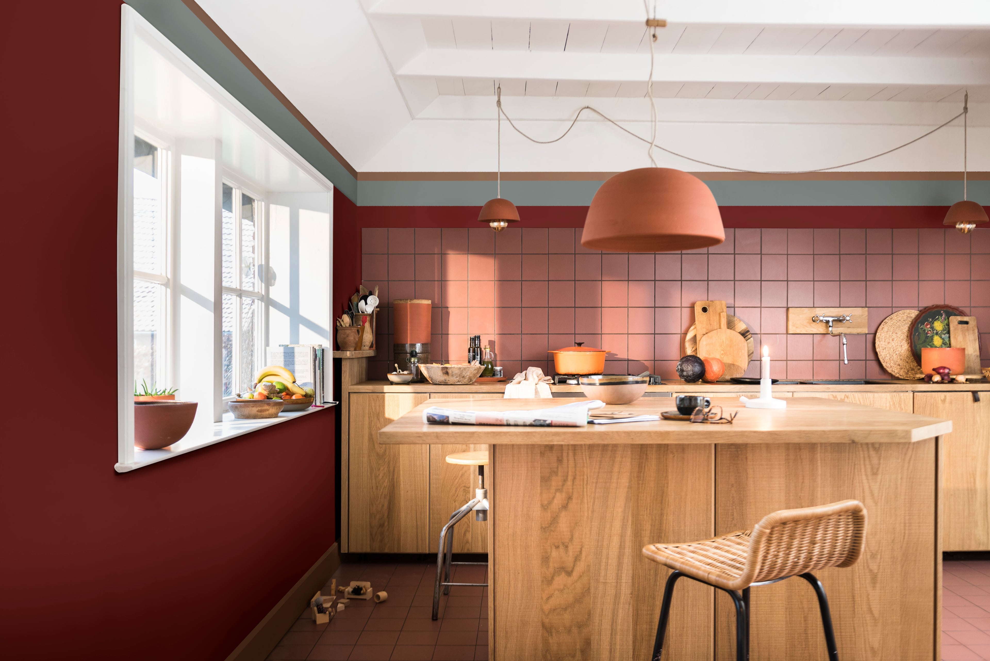 Keuken met warme rode kleur Puur Rabarber op de muur