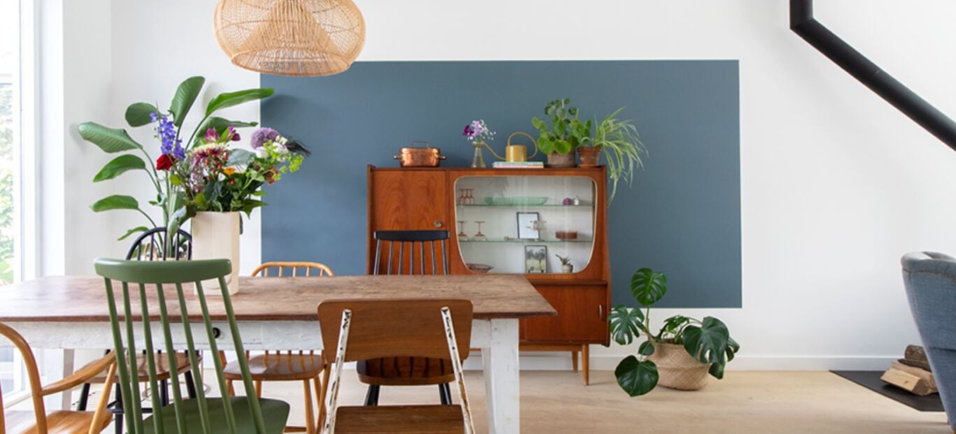 Een kleurvlak in de kleur Faded Indigo van Flexa achter de vintage kast.